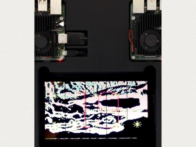 A technological setup featuring two circuit boards equipped with fans and USB ports, positioned on a sleek black surface. Below them, a brightly lit screen displays a colorful, abstract visualization with gridlines and patterns, resembling a computational or digital analysis interface. The contrasting elements of hardware and digital graphics convey a sense of innovation, merging physical components with dynamic software visualization.