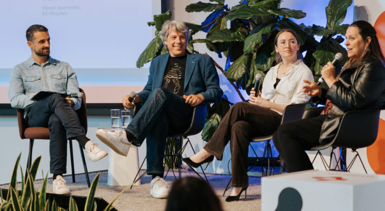 four people speaking on a stage