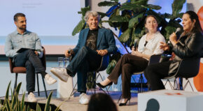 four people speaking on a stage