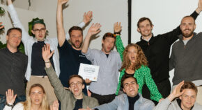 group of eleven people cheering on the winner