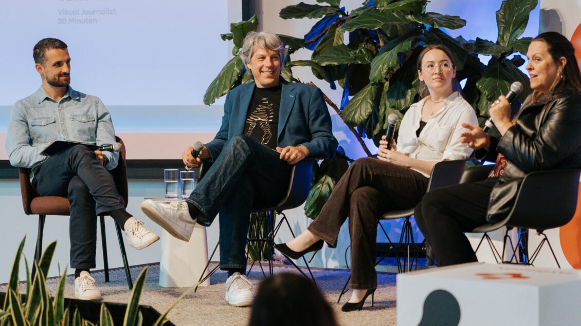 four people speaking on a stage