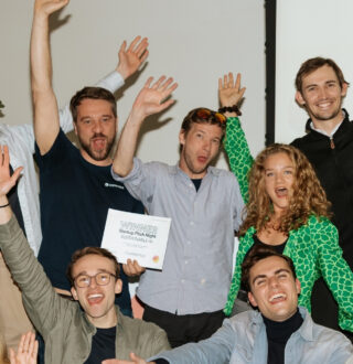 group of eleven people cheering on the winner