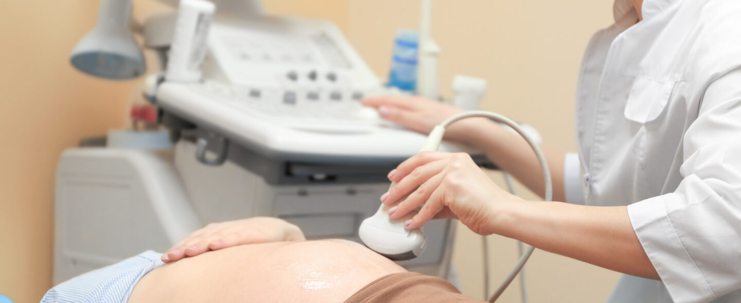 Pregnant woman undergoing ultrasound scan in modern clinic